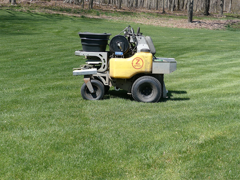 grass being fertilized by a fertilization truck, spray lawn care, fertilization program, new england lawn care